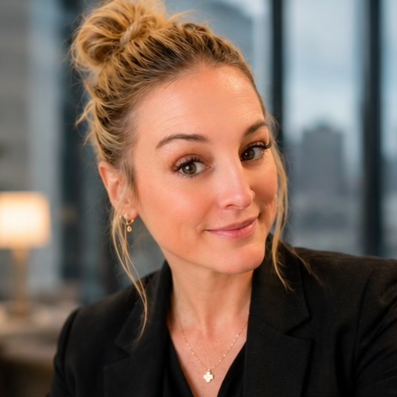 Sara Ann Straw in a black blazer with a city skyline behind her
